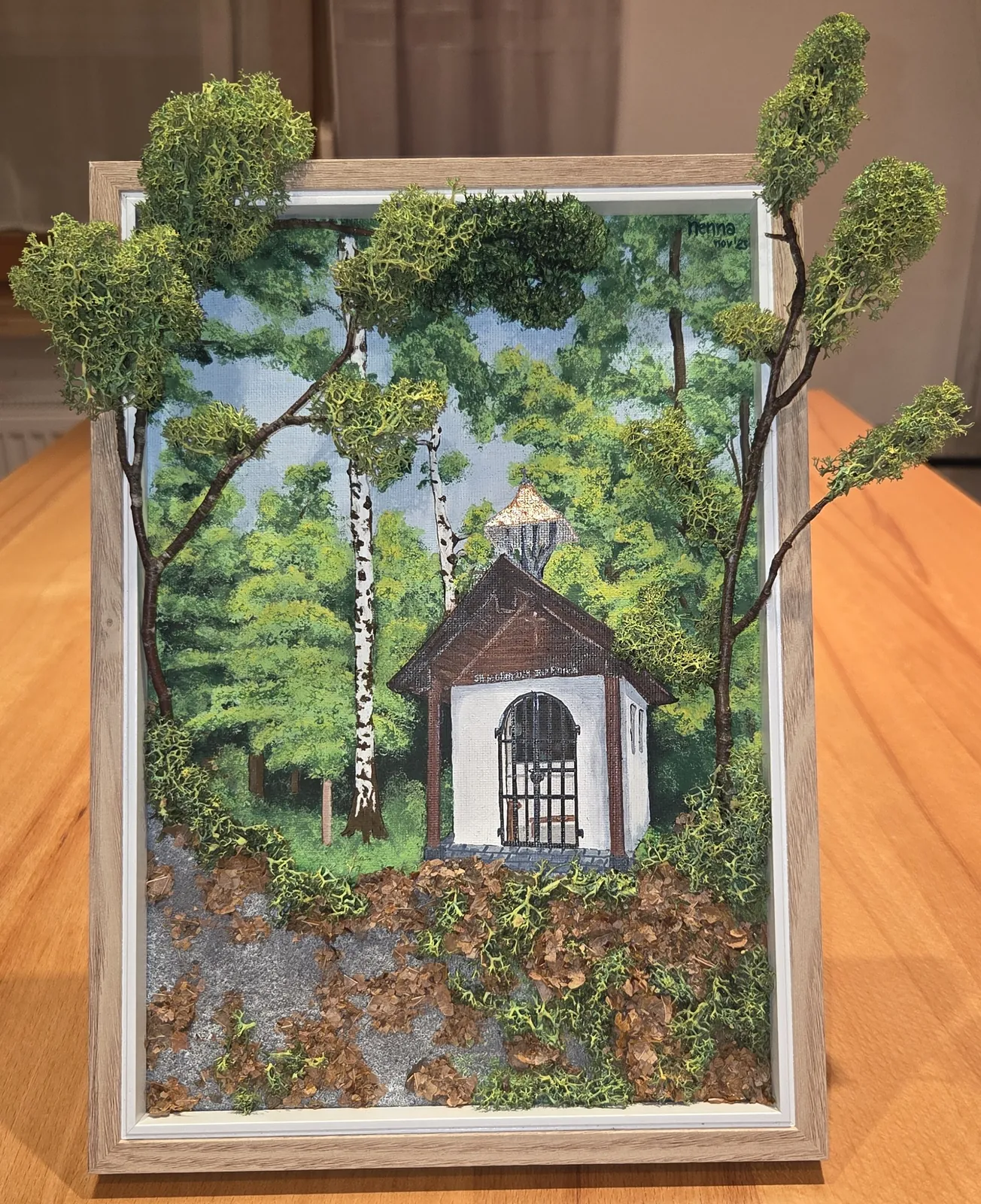 Gerahmtes Moosbild mit gemalter Waldkapelle und echtem Moos